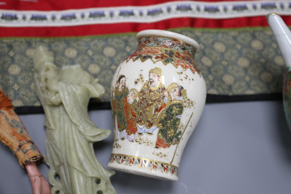 A small Cantonese porcelain teapot, a Satsuma vase, a silkwork panel, a doll and a broken soapstone figure